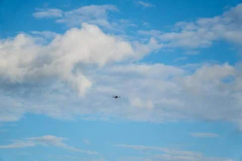 Small Quadcopter Drone Flying High in Cloudy Blue Sky Stock Photos