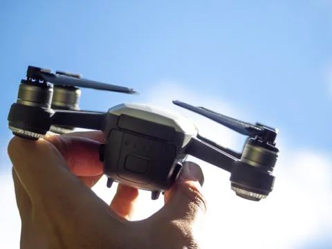 Small quadrocopter in hand, background blue sky. Back view. Stock Photos