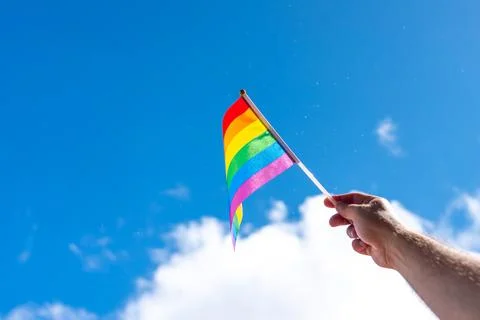 A small rainbow flag pointing to the sky as a sign of a sexual minority in a Stock Photos