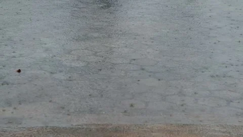 Small raindrops fall into a large puddle on the road. Stock Footage 304637087