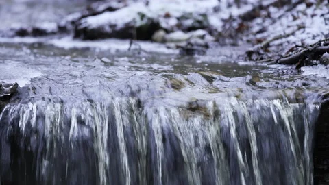 Small rapid river in winter. A small waterfall with snow in the background. Stock Footage 220054361