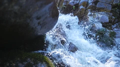 Small rapids with fast moving water running beside rocks Video stock 62420996