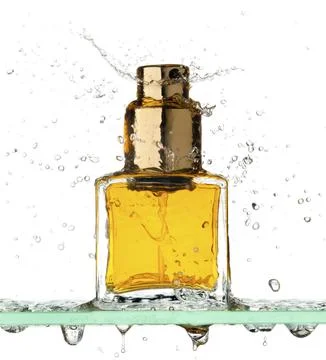 Small rectangular bottle of perfume all in a spray of water on a white Stock Photos