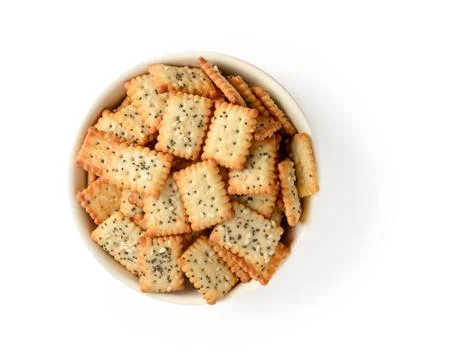 Small rectangular crackers with poppy and sesame seeds in a beige ceramic bowl Stock Photos