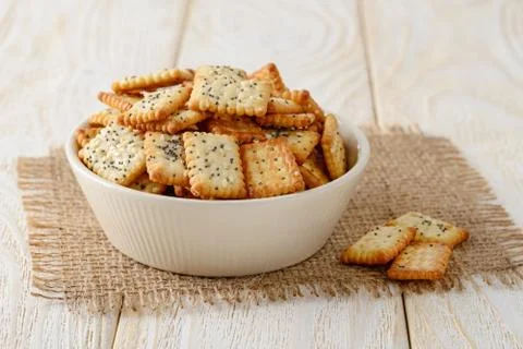 Small rectangular crackers with poppy and sesame seeds in a beige ceramic bowl Stock Photos