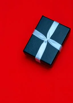 Small rectegular black gift box on a red background Stock Photos