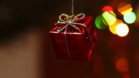 A small red box with a bow on a background of blurry Christmas lights. Stock Footage 116546330