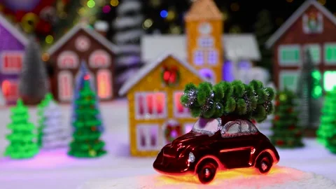A small red car moves against the background of a large Christmas town Stock Footage 292768049