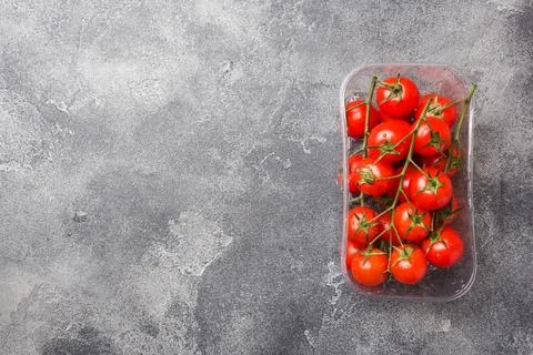Small red cherry tomatoes on dark table, top view. Copy space Foto stock
