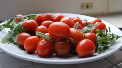 Small red cherry tomatoes plate with greens Stock Footage 4313471