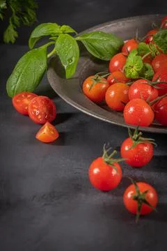 Small red cherry tomatoes on rustic background. Cherry tomatoes on the vine w Stock Photos
