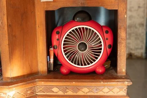 A small red children's model sitting fan is placed in a cupboard Stock Photos