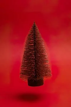 Small red christmas tree on red background Stock Photos