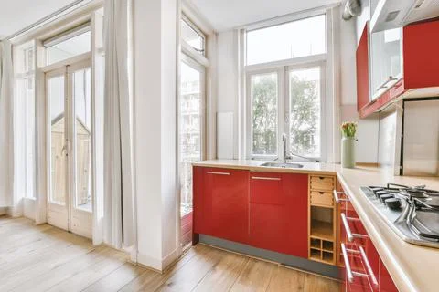 Small red corner kitchen near balcony Stock Photos