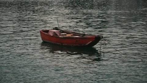 Small red fishing boat anchored in calm water Stock Footage 136575341