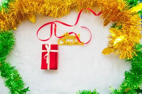 Small red gift box and gold merry christmas text with red ribbon Foto stock