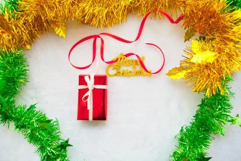 Small red gift box and gold merry christmas text with red ribbon Foto stock