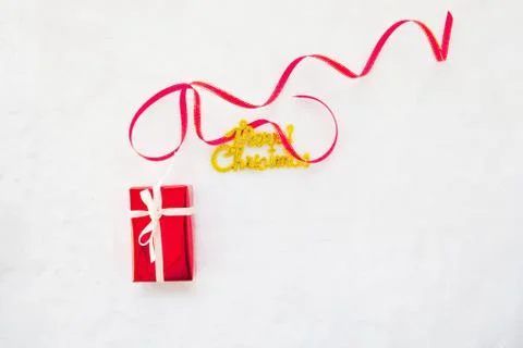 Small red gift box and gold merry christmas text with red ribbon Stock Photos