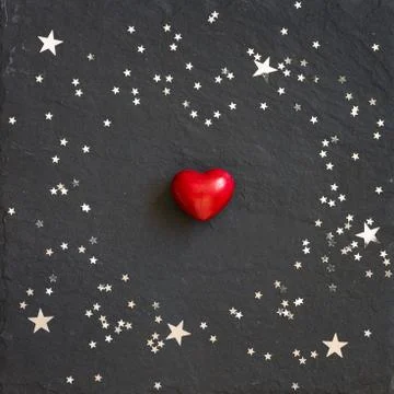 Small red heart on the black background with silver stars. Hearts and stars Stock Photos