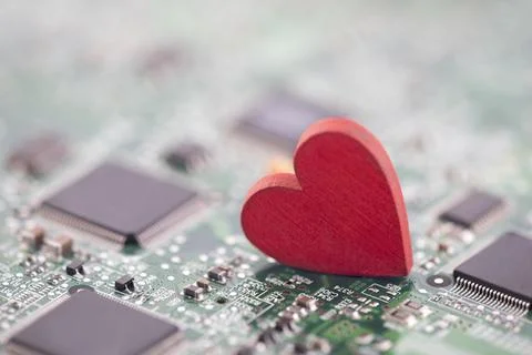 Small red heart on computer circuit board. Internet dating concept. Stock Photos