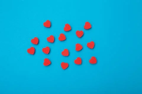 Small red hearts on a blue background. Background love symbol . Flat lay.Copy Stock-Fotos