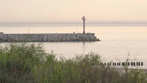 Small red lighthouse in Dziwnow Poland at sunset 스톡 동영상 338229049