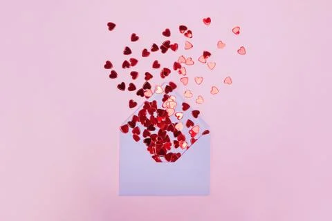 Small red shiny hearts with envelope on pink background Stock Photos
