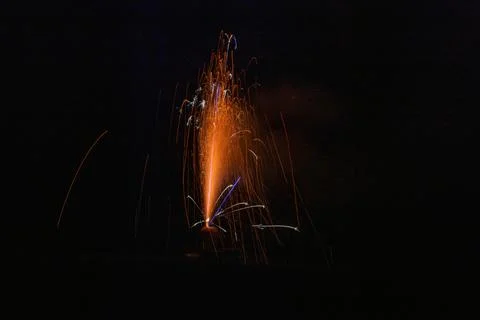Small red sparkler firework on ground in dark 스톡 사진
