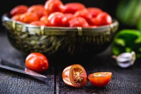 Small red tomato used as a culinary ingredient in rustic cuisine, sliced ??an Stock Photos