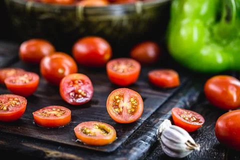 Small red tomato used as a culinary ingredient in rustic cuisine, sliced ??an Stock Photos