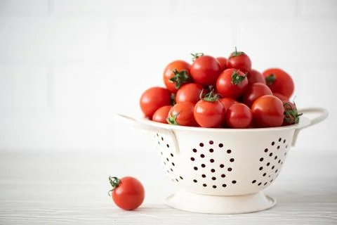 Small red tomatoes in a colander Stock Photos