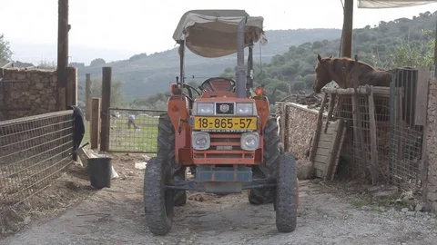 Small red tractor with horse and mountains in the background Stock Footage 83465481