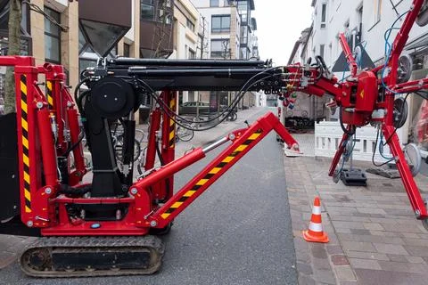 Small red tractor with suction cups to replace shop windows on a city street Stockfoto's