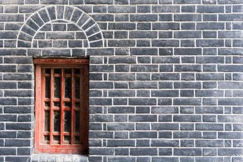 Small red window in a brick wall Фото