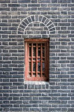 Small red window in a brick wall Stock Photos