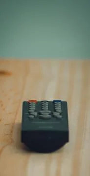 Small Remote controller lay flat on a wooden surface low angle photograph, Stock Photos