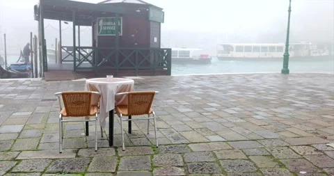 Small restaurant table and empty chairs next to gondola service and water bus Stock Footage 150392429