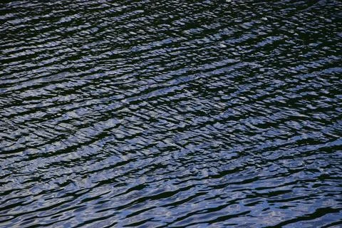 Small ripples on the water surface. Evening dusk descends on the river. Stock Photos