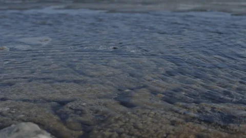 Small ripples in the water,covered with thin ice,bottom is brown and in bubbles Stock Footage 124426062