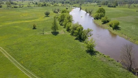 Small river and green meadow seen from above in spring light Stock Footage 90438274