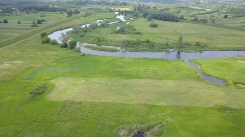 Small river and green meadow seen from above in spring light Video stock 90464440