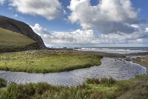 Small river and stream flows on to beach at Duckpool Cornwall Foto stock