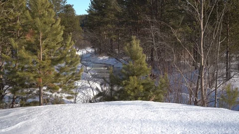 A small river covered with ice among white snowdrifts in the forest. Stock Footage 127072566