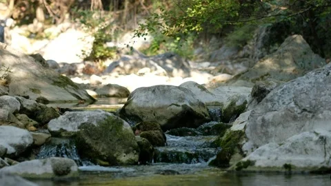 Small river enveloped with rocks and the rocks reflected in the calm water su Stock Footage 139299071