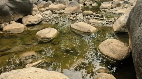 A small river flowing in the rocky mountains during the dry season Stock Footage 321283360