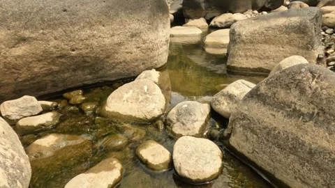 A small river flowing in the rocky mountains during the dry season Stock Footage 321283367