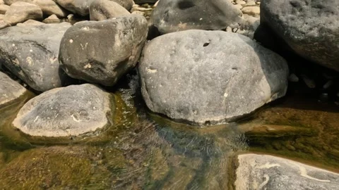 A small river flowing in the rocky mountains during the dry season Stock Footage 321283370