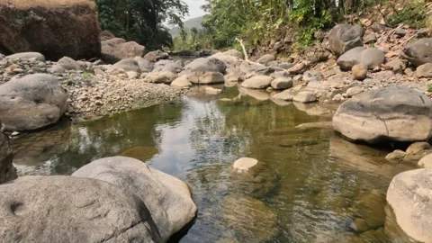 A small river flowing in the rocky mountains during the dry season Stock Footage 321283489