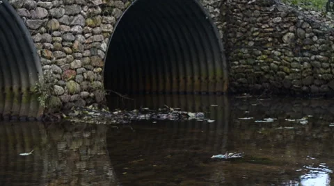 Small river flowing through a bridge Stock Footage 68799508