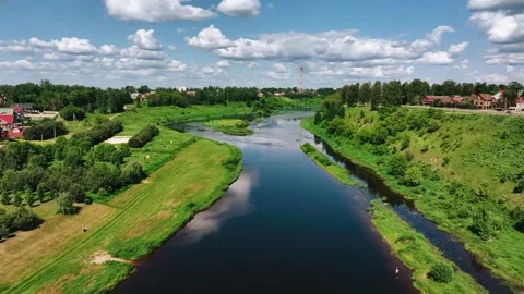 A small river flows among the high banks in a small town Stock Footage 331462061
